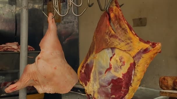 Carne fresca cruda colgando de ganchos en el mercado al aire libre, carnicería, control de calidad — Vídeos de Stock