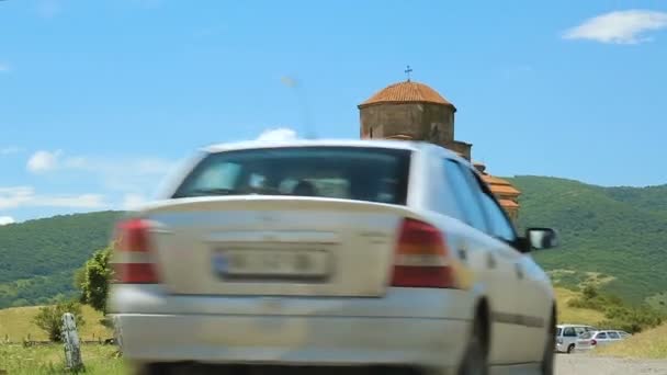 Αυτοκίνητα που φθάνουν στο Jvari μοναστήρι στο βουνό, θρησκευτικό μνημείο, γεωργία — Αρχείο Βίντεο