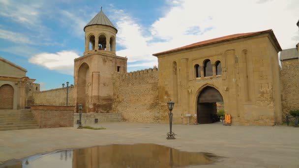 Bell tower of Svetitskhoveli Cathedral reflecting in water, religious building — Stock Video