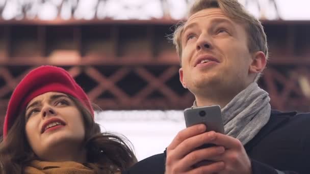 Молода туристична пара шукає карту в додатку мобільного телефону, загубитися в невідомому місті — стокове відео