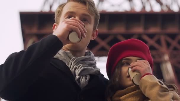 Schönes Paar trinkt gemeinsam Kaffee im Freien, umarmt sich und wird warm — Stockvideo