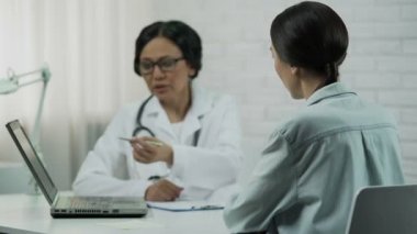 Kadın doktor kötü tanı, hasta üzgün, çaresiz hastalık hakkında bilgilendirir