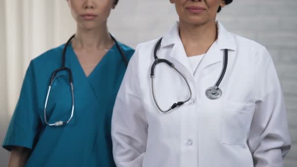 Médicos sorrindo e cruzando as mãos, ajuda altamente qualificada do pessoal médico — Vídeo de Stock