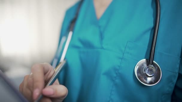 Female nurse with stethoscope writing symptoms, diagnostics and prescriptions — Stock Video