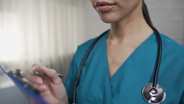 Enfermera llenando el formulario del hospital durante la ronda de sala, actitud cuidadosa hacia los pacientes — Vídeo de stock