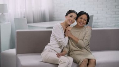 İki kadın mutlu bir şekilde iletişim kurmak, gülümseyerek ve kucaklayan, güven ilişkisi içinde