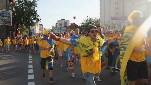 КИЕВ, Украина - CIRCA JUNE 2012: Футбольные болельщики в городе. Возбужденные болельщики сборной Швеции по футболу переходят дорогу громко скандируя — стоковое видео