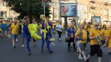 Kiev, Ukrayna - yaklaşık Haziran 2012: Futbol taraftarları şehirdeki. Diğer fanlar kalabalıktan dışarı ulusal bayrak renk duran komik elbiseli adamlar