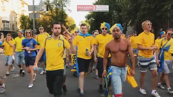 КИЕВ, Украина - CIRCA JUNE 2012: Футбольные болельщики в городе. Активные футбольные болельщики спешат на стадион, чтобы поддержать команду в конфронтации — стоковое видео