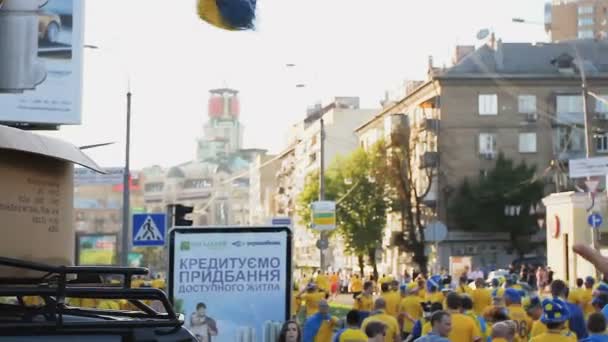 КИЕВ, Украина - CIRCA JUNE 2012: Футбольные болельщики в городе. Организаторы футбольных соревнований, раздающие болельщикам атрибуты болельщиков — стоковое видео