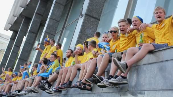 Kyjev, Ukrajina - cca červen 2012: Fotbaloví fanoušci ve městě. Veselá fanoušky sedící na parapetech zpívání na podporu jejich fotbalový tým — Stock video