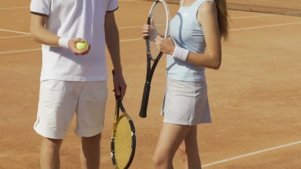 Man och kvinna stående på domstolen och diskutera sista tennismatch, sport, närbild — Stockvideo