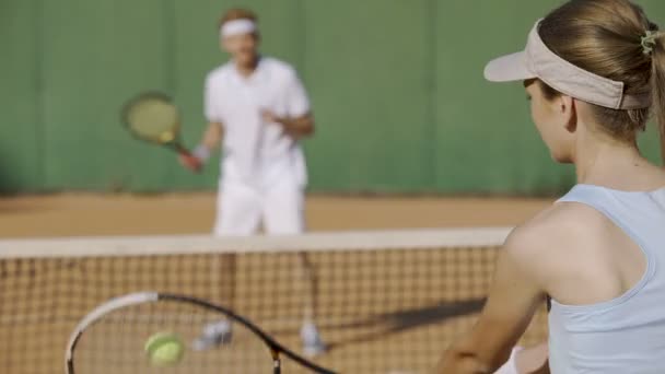 Ženské bít tenisový míček raketou na sportovní klub, hrající s protihráčem