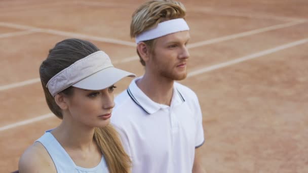 Gemotiveerde vrouwelijke en mannelijke tennissers kijken scorebord, succes in de sport — Stockvideo