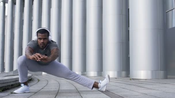 Konzentrierter Sportler beim seitlichen Ausfallschritt zur Vorbereitung der Achillessehnenmuskulatur — Stockvideo