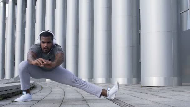 Concentrated sportsman doing the lateral lunge to prepare hamstring muscles Video Clip