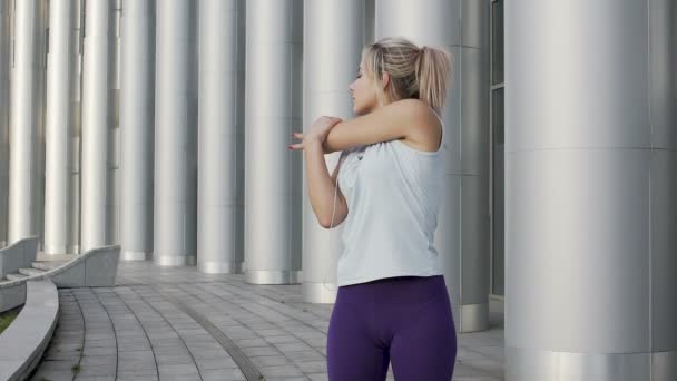 Chica linda saludable estirando los músculos y escuchando música, disfrutando del ejercicio — Vídeos de Stock