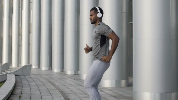 Homme athlétique en place au ralenti, faisant de l'exercice et soulevant les jambes — Video