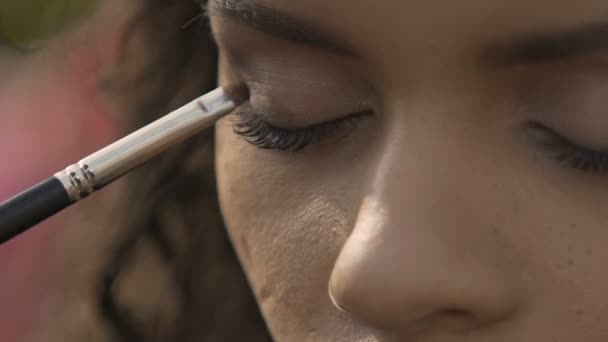 Artista de maquiagem experiente aplicando sombra nos olhos, preparando modelo para desfile de moda — Vídeo de Stock