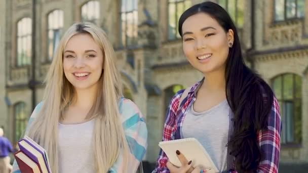 Multiethnic females with notebooks smiling at camera, high school education — Stock Video