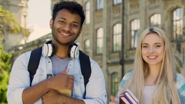 Kvinnliga och manliga studenter som ler mot kameran, visar tummen upp, utbildning av hög kvalitet — Stockvideo