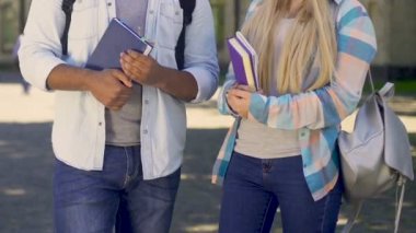 Konuşmayı, kitaplar, tutan kadın ve erkek öğrencilerin kolej arkadaş