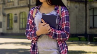 Yalnız holding notebook, arkadaşsız, yalnızlık ayakta üzgün kız öğrenci
