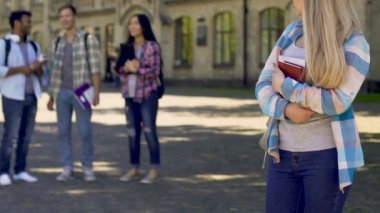 Gülüyor ve yalnız hüzünlü kız bir yana, zalim ayakta için işaret eden öğrenciler bulling
