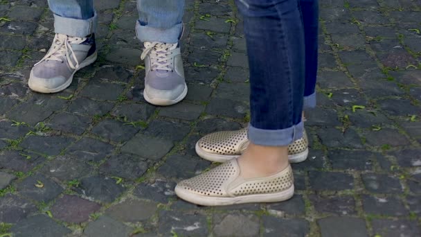 Female and male legs standing on cobble-stoned road, shoes and jeans style — Stock Video