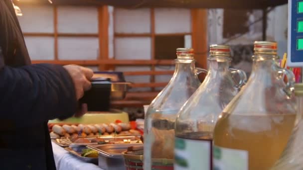 Мужчина платит продавцу и берет столовые приборы, ест на фестивале уличной еды — стоковое видео
