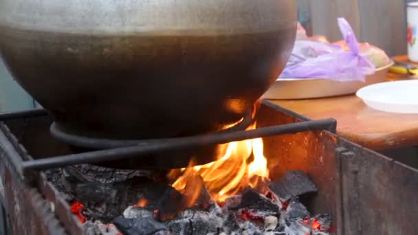 Food boiling in huge cauldron standing on fire, traditional cooking open air — Stock Video