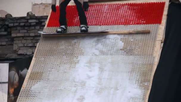 Jeune espiègle montrant des tours de snowboard, se préparant pour la compétition — Video