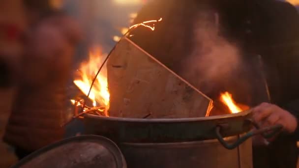 Människor som uppvärmningen framför stora moms med eld, försöker få värmas nära bonfire — Stockvideo