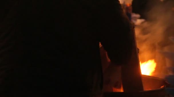 Протестующие сжигают костры в бочках, чтобы согреться на улице Холодного Города — стоковое видео