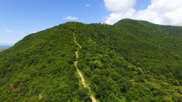 Aerial flight over beautiful mountain with art installation on top, nature — Stock Video
