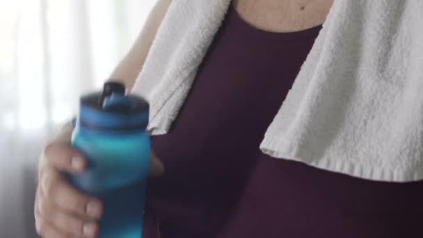 Счастливый толстяк в спортивной одежде сохраняет водный баланс после тренировки дома — стоковое видео