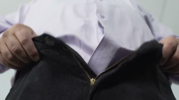 Bottom view of obese male trying to pull his pants zipper, mans health, closeup — Stock Video