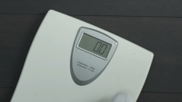 Толстый мужчина наступает на весы здоровья и глядя на дисплей, дополнительный вес — стоковое видео