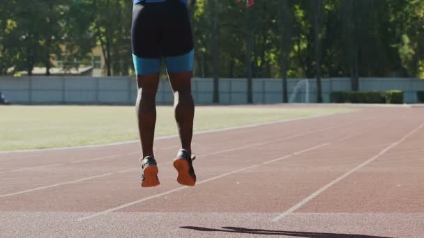 Voetballer houdt zijn lichaam en spieren gespannen, traint hard in het stadion, sport — Stockvideo