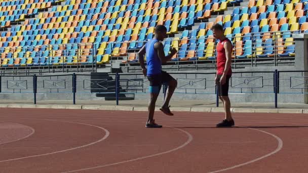 Entrenador ayudando a su deportista a calentar y controlar sus cargas de trabajo en el entrenamiento — Vídeos de Stock