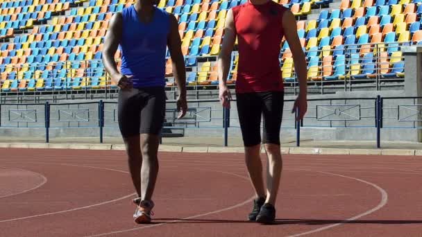 Atletas seguros de sí mismos caminando al vestuario después de agotador entrenamiento, lento-mo — Vídeo de stock