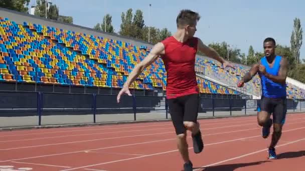 Atletas carrera de relevos de entrenamiento en estadio vacío, trabajo en equipo, aspiración a ganar — Vídeo de stock