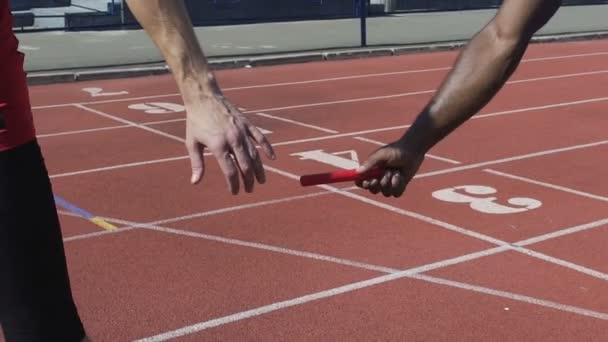Close-up beeld van deelnemer afleveren van baton aan volgende runner, Wereldkampioenschap — Stockvideo