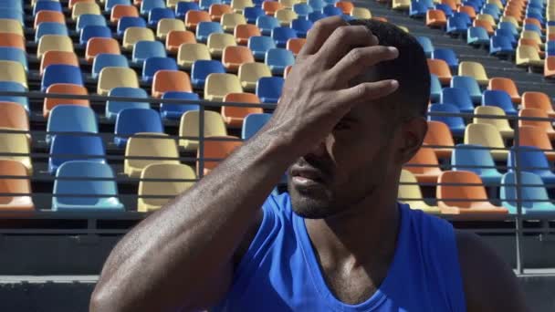 Atleta olhando para placar aguardando seus resultados limpando o suor da testa — Vídeo de Stock