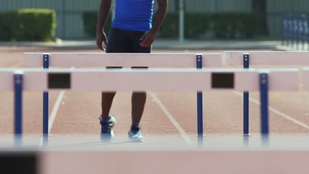 Hispanic sportsman stretching and warming up before practicing in hurdle race — Stock Video