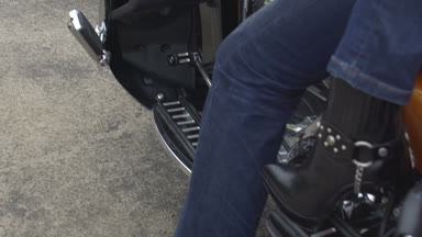 Bacaklar yüksek topuklu erkek motorcu motosiklet üzerinde oturan kadın, yakın çekim