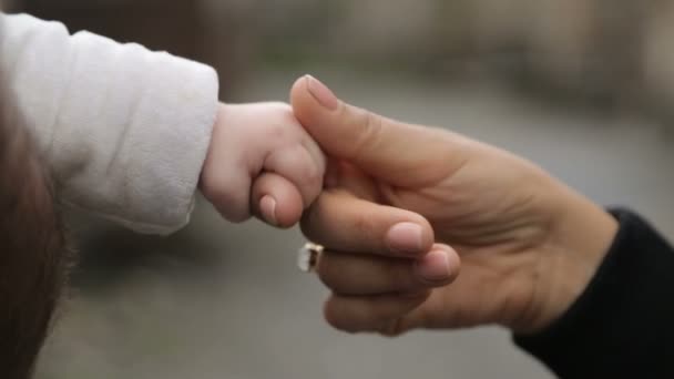 Madre sosteniendo la pequeña mano del bebé con ternura y cuidado, sentimientos maternos — Vídeos de Stock