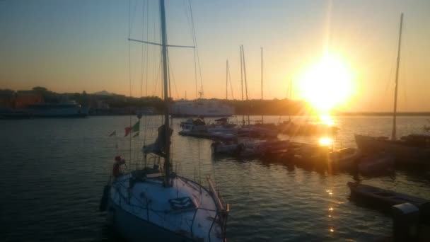 Jachten en boten aangemeerd in de buurt van pier, geweldige zonsondergang en natuur, gouden uur — Stockvideo