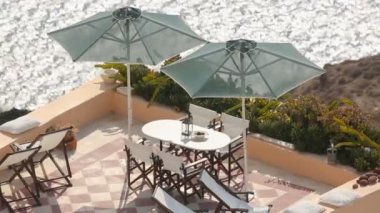 Öğle Yemeği masanın altında şemsiye terasta yaz resort altında deniz cliff üzerinde