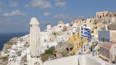 Santorini Adası Yunanistan, turizm Yunan bayrağı karşı rüzgarda sallanan evler